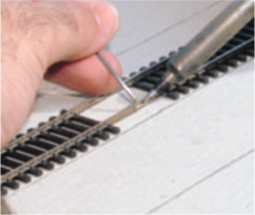 Рис 1. Чтобы избежать перегибов флексов на кривых участках, удалим по три шпалы с каждого конца рельс. Затем состыкуем рельсы между собой и обязательно пропаяем места стыков, для надёжного электрического контакта. Удалённые шпалы можно вернуть на место после помещения рельс на предназначенное для них на макете место. 