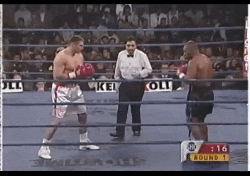 Майк Тайсон нокаутирует соперника сокрушительным  задним свингом в первом раунде.