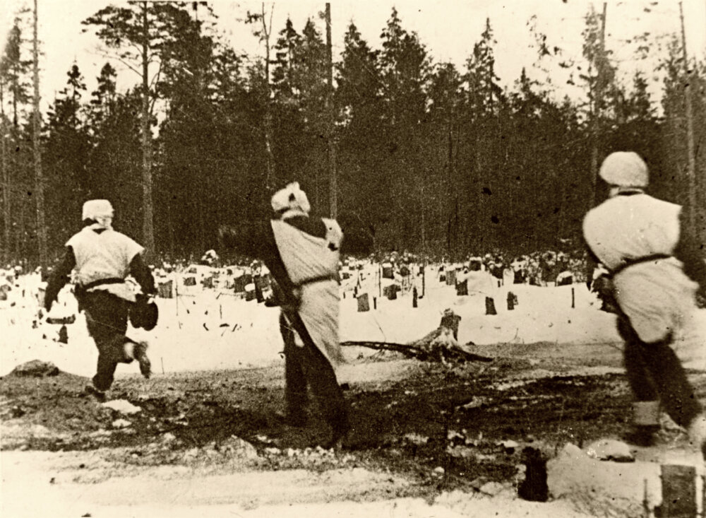 Трое немецких солдат перебегают просеку в лесу под Ленинградом.