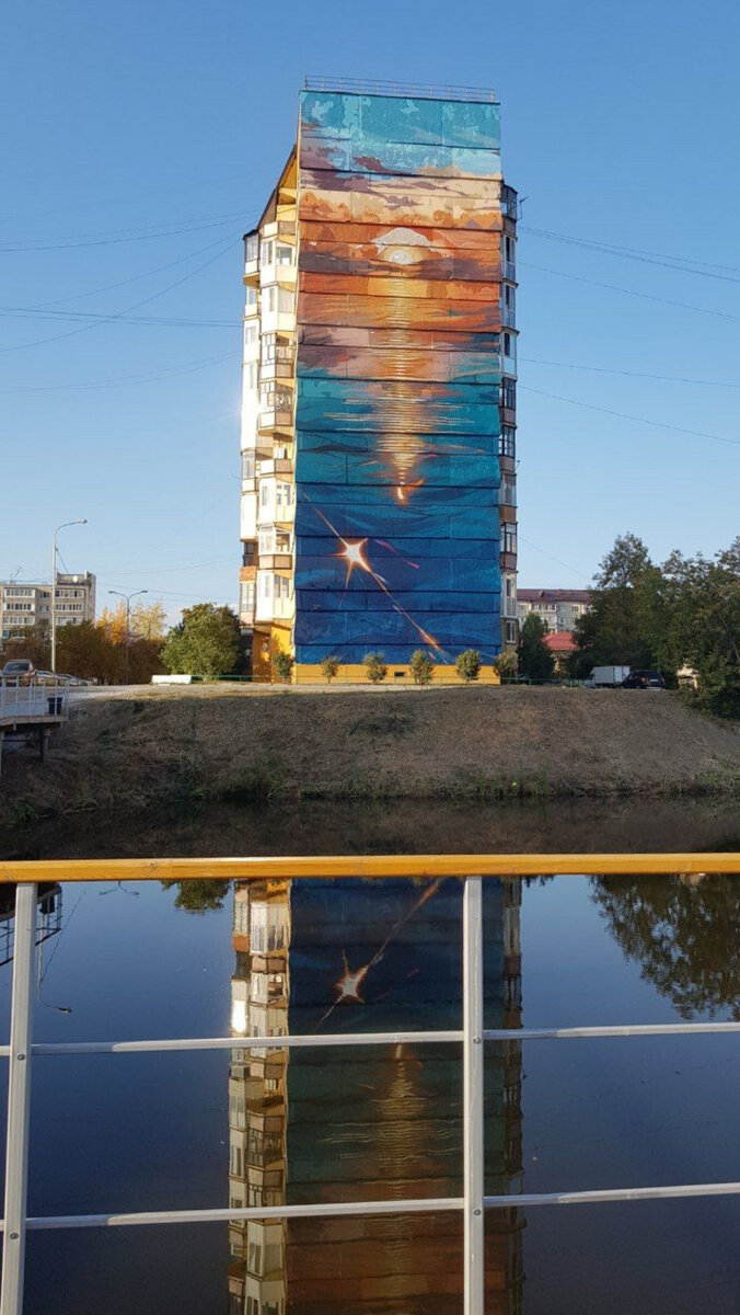    Возле объекта на одном из зданий появился мурал. В полосах света от Солнца зашифровано послание. Это звуковые волны из фразы мэра города Руслана Кухарука. Расшифровывается послание как: «Тюмень — город, где начинается путь».