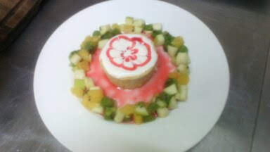 В стаканчике из печенья и сливочного масла с декором из свежих фруктов.