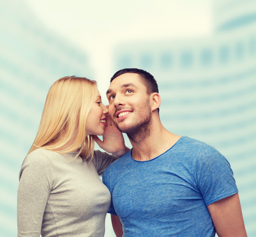 девушка шепчет на ухо парню