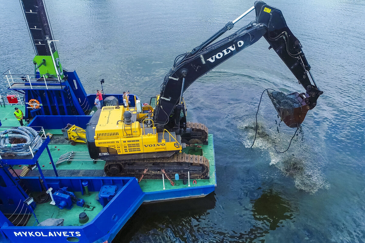 Земснаряд на базе 70-тонного экскаватора Volvo выполняет работы по углублению речного дна.