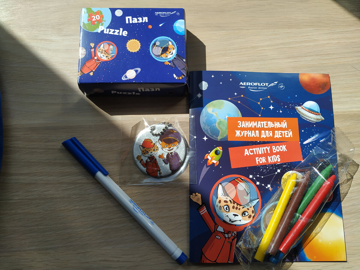 содержимое рюкзака. Пазл, ручка, брелок, книжка с наклейками, восковые мелки. Листай 👉