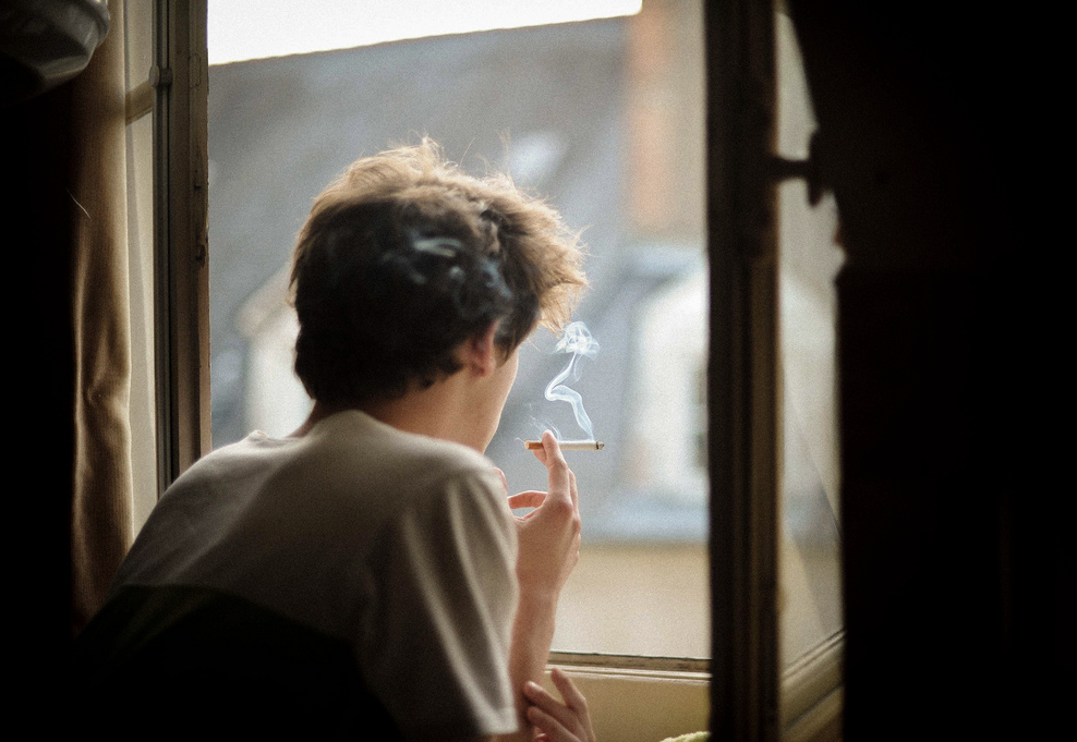 Курит сосед в квартире снизу. Человек курит у окна. Мужчина курит у окна. Человек возле окна. Человек у окна с сигаретой.