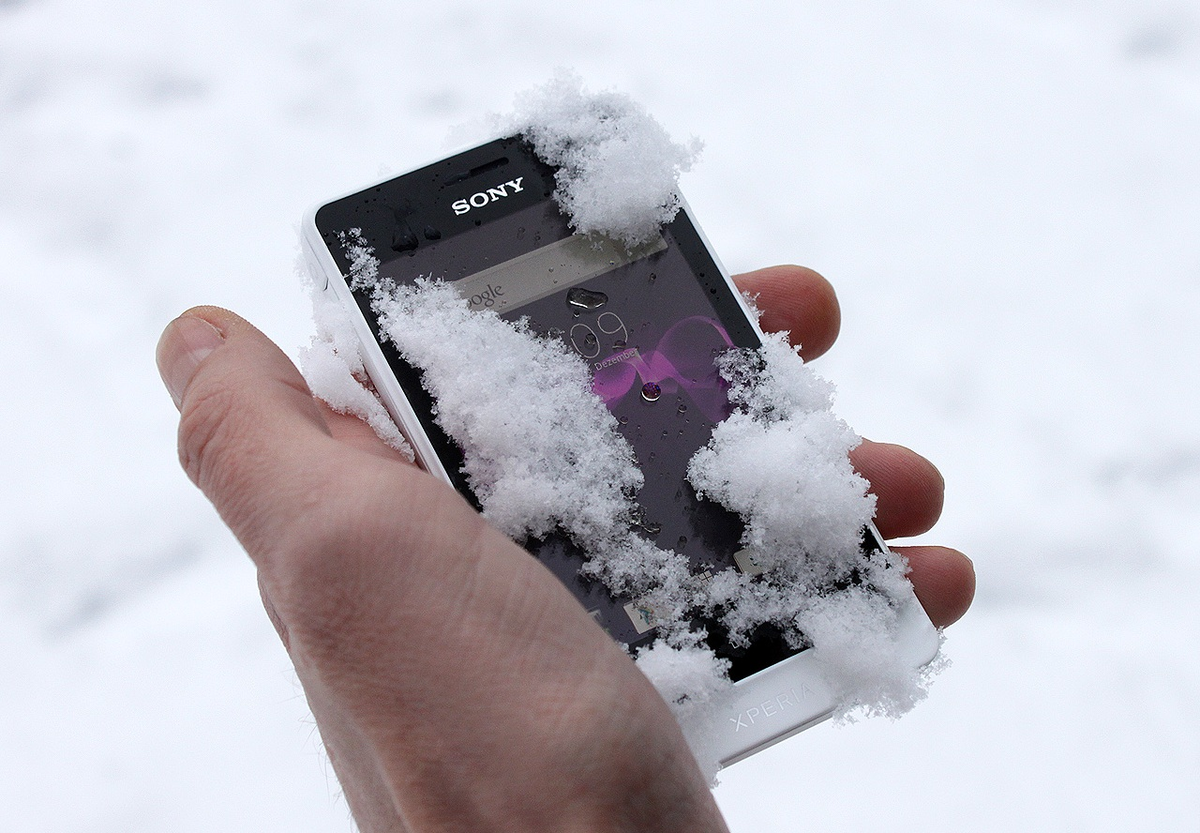 Телефон выключается морозе. Смартфон на холоде. Смартфон в сугробе. Телефон в снегу. Смартфон в снегу.