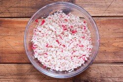 ШАГ 1:
Подготовить указанные продукты по списку. Крабовые палочки (одну крабовую палочку отложить целой в сторону) нужно немного подморозить и натереть на мелкой тёрке. Если они плохо натираются, то очень мелко порезать. У меня они плохо натирались, поэтому часть я натёрла, часть очень мелко порезала. 1/3 натёртых крабовых палочек отложить в сторону, остальные сложить в глубокую миску.