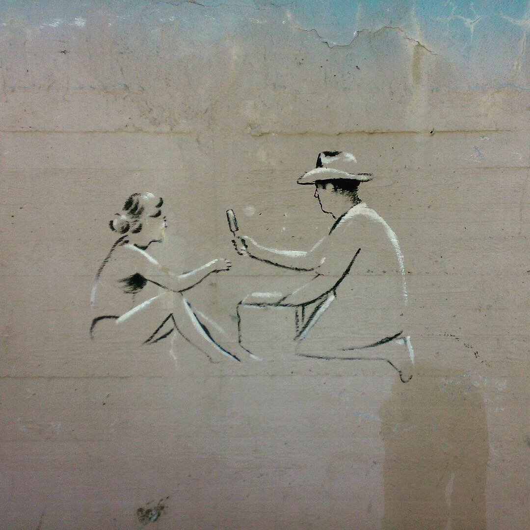 Я иду по пляжу с двумя сумками и лотком на ремнях. Море штормит, но людей много – лежат, сидят, играют, бегут босиком по песку, оставляя следы из пяти ямок и вмятины. Следы живут до следующей волны, захлёбываются пеной и тонут, но люди делают новые. Мои следы крупнее и глубже. На мне ботинки и обрезанные по колено джинсы. Я сам обрезал. Я все делаю сам. Я живу один. Женщина, которую я хочу, вряд ли захочет быть со мной. Каждый вечер она выходит из машины. Чтобы купить такую, мне надо работать восемь лет, семь месяцев и две недели. Это если цены не изменятся, и если арендовать квартиру в дорогом районе, где живет она. Я знал её еще девочкой. Резинки на её хвостиках всегда были в цвет платья. К голубому – голубые, к желтому – желтые, к розовому – розовые. Мне не нравятся другие женщины. Они лежат, раздвинув толстые или худые ноги и вывалив из купальников губы – волосатые, бритые, мясистые, тощие, надутые, сморщенные. Даже если я не смотрю им туда, я всё равно это вижу. Они жуют, орут на детей и мужей, хохочут, визжат.  Я не хочу ни одну из них. Я хочу её… Она никогда не будет моей, я знаю это. Она выросла и носит шляпы. Всегда в цвет платьев. К красному – красная, к белому – белая, к желтому – соломенная. Она элегантно наклоняет голову, выходя из машины. Я живу в маленькой квартирке возле её дома. Дорого и далеко до работы, но зато я каждый вечер вижу, как она наклоняет голову, выходя из машины...
На мне тоже соломенная шляпа. Без неё нельзя. Я провожу на солнце по восемь часов в день, на пяти языках предлагая напитки и мороженое. Иврит, русский, английский, французский и немецкий. На иврите и английском  говорят все мои конкуренты, этим никого не удивить, а на трех других языках только я. Я сам выучил фразы. У меня две сумки и лоток на ремнях. Ремни давят шею, и сумки оттягивают руки, но я привык. Ко всему привыкаешь. Я знаю свой пляж как свои старые ботинки. От отеля «Марина», где живут эти ненормальные, что лезут в воду в резиновых костюмах с привязанной к ноге доской и ничего не покупают, до длинного волнореза, где мало отелей и людей. Туда приходят старушки и пожилые пары, и они тоже не покупают, потому что в их клетчатых сумках всегда есть вода и еда. Я хожу туда и обратно целый день. Люди меняются, но люди не меняются. Лежат, сидят, гуляют, бегут по песку, оставляя следы, живущие до следующей волны. Мой маршрут начинается от высокой стены отеля «Марина», той, что с рисунками. Необыкновенными рисунками. Я знал художника, его звали Рами. Высушенный солнцем, нелюдимый, сутулый человек. Однажды утром на бетонной стене появились силуэты людей, оживлённые углём и мелом и синее море в цвет отеля «Марина». В бетонной синеве резвятся нарисованные дети. Три девушки сидят на полотенцах, глядя в лестницу, ведущую к отелю. У них прямые спины и угольные волосы, а тела полны белой надежды. Полная дама на лежаке глядит сквозь угольные очки на юношу, который смотрит ей между ног, в черный треугольник. Забелённая под обаяние похоть. Двое молодых людей лежат на песке, оглядывая мир, который пока принадлежит им. Над мусорным баком в форме дельфина – пожилая пара. Он, опираясь о палку, поднял ступню, а она вытаскивает из ступни занозу. Седая любовь, черная старость. Толстый разносчик напитков в шляпе, с лотком на ремнях и сумками тяжело опустился на колено перед покупательницей. Она держит белый рожок мороженого. Разносчик похож на моего друга Шимона. Такой же неуклюжий. Ниже, в углу, у самых тротуарных плит – худенькая белая девочка завязывает волосы в хвостик. Я стараюсь не смотреть на неё. Но даже если я не смотрю, я все равно её вижу...  
Нарисованные люди лучше настоящих, тех, что сутками торчат на пляже. Их тела живей, а чувства ярче. Не знаю, как Рами сумел это сделать. Он был гением. Он умер. Его нашли на песке возле моря ранним утром, когда песок еще совсем холодный. Говорят, он улыбался. Я видел след от его мёртвого тела, которое тащили к дороге. Длинный, извилистый след. Его затоптали пришедшие загорать люди к полудню, когда песок становится тёплым. Солнце одинаково равнодушно ко всем. Все едут к солнцу, все хотят пить, все хотят охладиться. У меня дешевле и я обслуживаю на русском, французском и немецком, не считая иврита и английского. Я не останусь без работы. У моего друга и основного конкурента Шимона такая же шляпа, такой же лоток на ремнях и такие же сумки. Но он говорит только на иврите и немного по-русски, и у него большой живот. Он идет медленней меня. К тому же на него всегда лают собаки, и он обходит людей с собаками стороной.
«Лают, потому что я вкусный, а ты твердый и костлявый, Полиглот», – так он шутит.
Полиглот – моя кличка. Один русский как-то окликнул меня: «Эй, полиглот!» И кличка прилипла. Меня здесь все так называют. Я не обижаюсь. Мне даже нравится. Пусть себе.
Они продают вполовину от моего, так что волноваться не стоит...