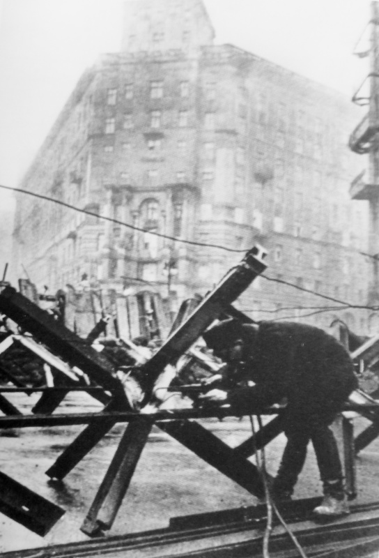 Житель Москвы соединяет противотанковые заграждения перед баррикадой на перекрестке Большой Дорогомиловской улицы и улицы Раевского. 
