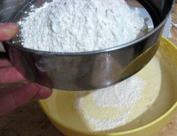     Коржи торта готовятся из песочного теста. Есть несколько его видов. Например: дрожжевое песочное тесто, тесто с разными наполнителями, такими как творог или разрыхлитель. Но мы приготовим самое обычное тесто, без каких-либо особых ингредиентов, и вместе с тем оно получится очень вкусным. Основа такой тестовой смеси состоит из муки и сливочного масла. И главное - чем больше в тесте масла, тем оно более получается рассыпчатым. И, конечно, очень важно качество муки. Всегда берите данный компонент высшего сорта. Наши ингредиенты рассчитаны на торт, весом примерно в 1,5 килограмма. А этого достаточно, чтобы порадовать самых маленьких сладкоежек, и оставить еще пару кусочков для взрослых. Итак, приступим! Просеиваем муку через сито на разделочную доску или заранее подготовленный кухонный стол. В данном случае это необходимо сделать для того, чтобы не попадалось комков и всякого сора. Мука должна дышать и быть насыщенной кислородом.   