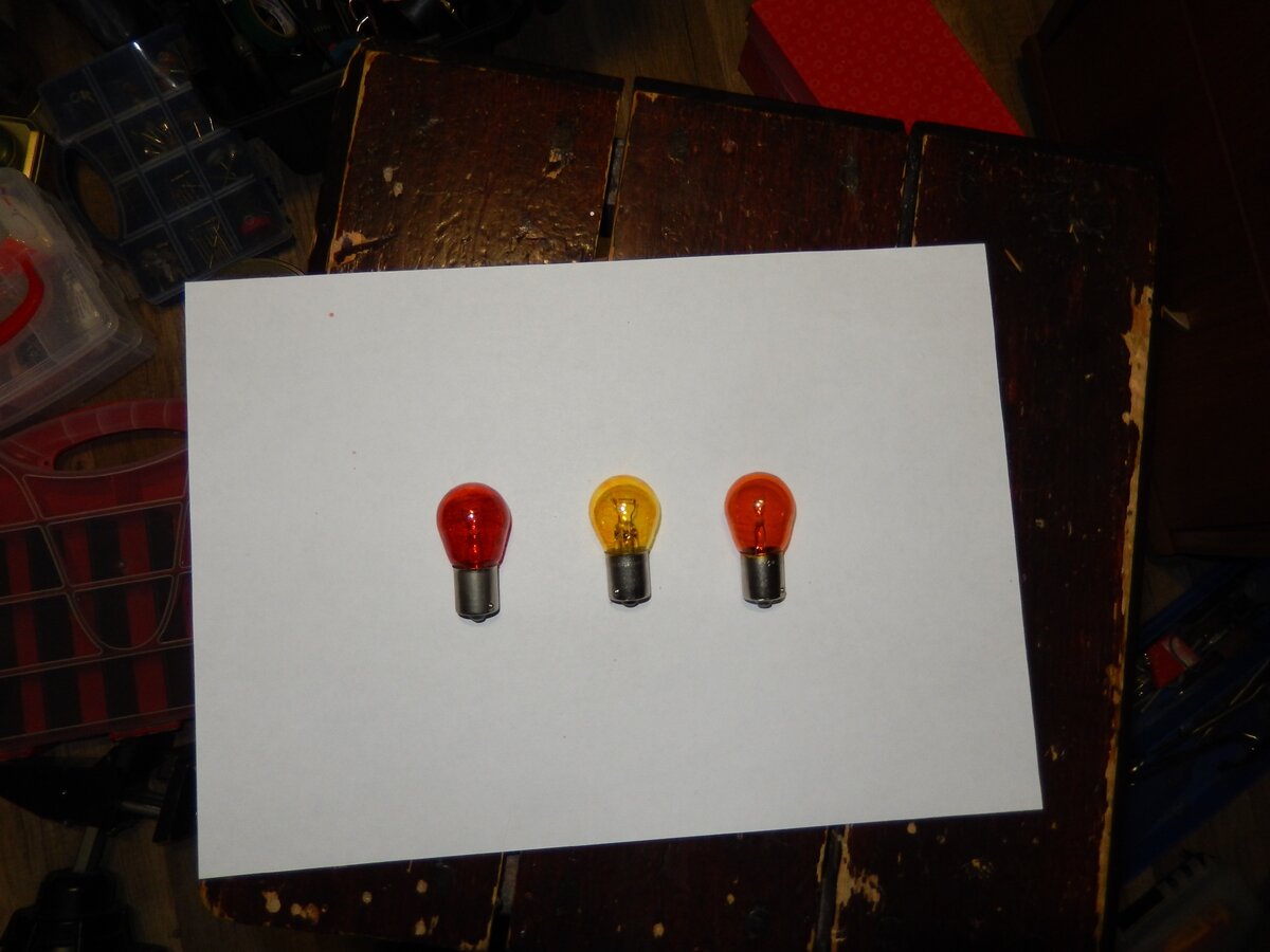 Слева окрашенная лампа смесью красного и желтого цапонлака, в центре лампа окрашена желтым, бледновата для указателя поворотов, справа фирменная немецкая янтарная лампочка  PY21W фирмы Hella.