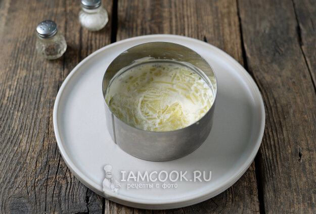Установите сервировочное кольцо. Выложите слой тертого картофеля. Смажьте майонезом.