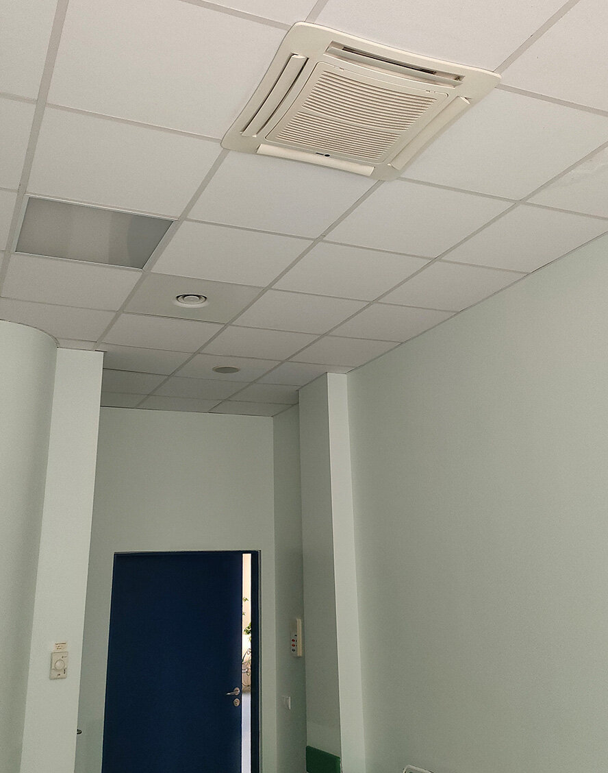 Потолочный кондиционер, регулятор на стене слева.