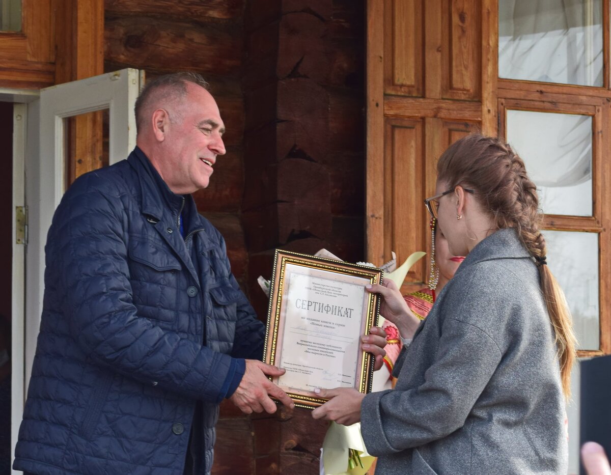 Сертификат победителю вручает поэт Виталий Молчанов