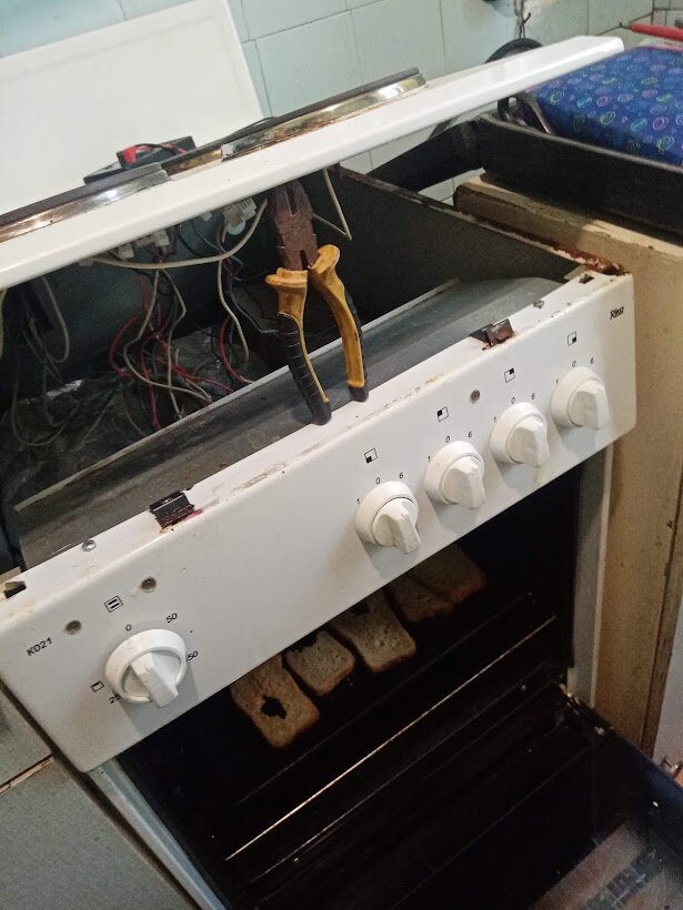 Электроплита Rika Рика в разобранном состоянии. Передняя панель с переключателями установлена своими пазами в направляющие на корпусе электроплиты