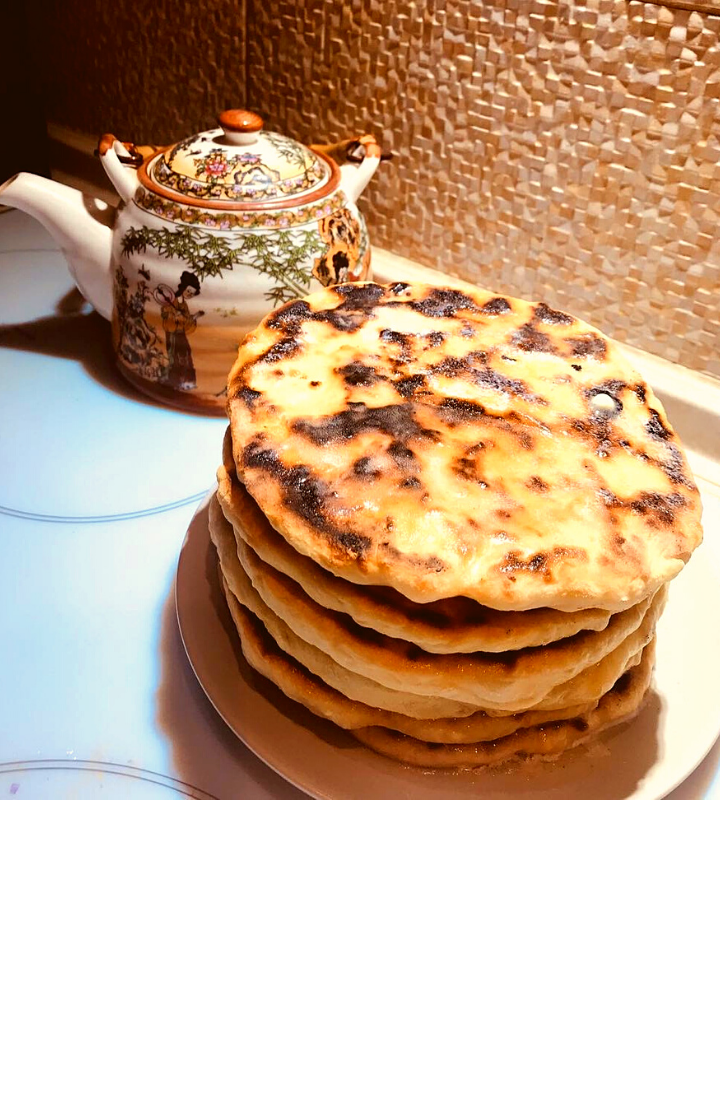 Это традиционные национальные блины чеченцев. Готовить их меня научила когда-то свекровь, которая долгое время жила в Чечне. И я теперь иногда балую своих домочадцев.
⠀
Рецепт совсем простой. Для приготовления нужен кефир, сода, мука пшеничная, соль, сухой домашний творог, яйцо небольшое, лук зелёный, масло сливочное.
Я готовлю без лука.
⠀
Тесто замешиваю, как для оладьев, но только больше муки, что бы получилось, как на пирожки.
Потом делим на части, формируем небольшие шарики, кладём во внутрь подсоленный творог (в него можно добавить лук) и раскатываем в лепешку.
⠀
Жарим лепешки с двух сторон на сухой сковороде.
Горячие лепёшки обильно смазываем сливочным маслом, разрезаем на сигменты и завтрак готов.  Можно ещё и со сметанкой подать. Приятного аппетита!