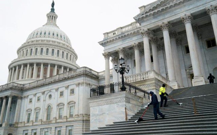 ФОТОГРАФИЯ: Рабочие сгребают снег со ступеней Капитолия США в Вашингтоне, США, 16 декабря 2020 г.