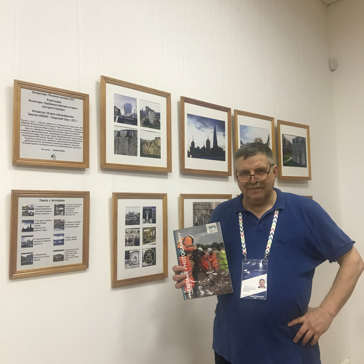 Мой фотопортрет на фоне фотовыставки "Мгновение наследия 2022". В моих руках номер журнала Секции "Археология.Наследие" PRS  (Архив моей семьи).