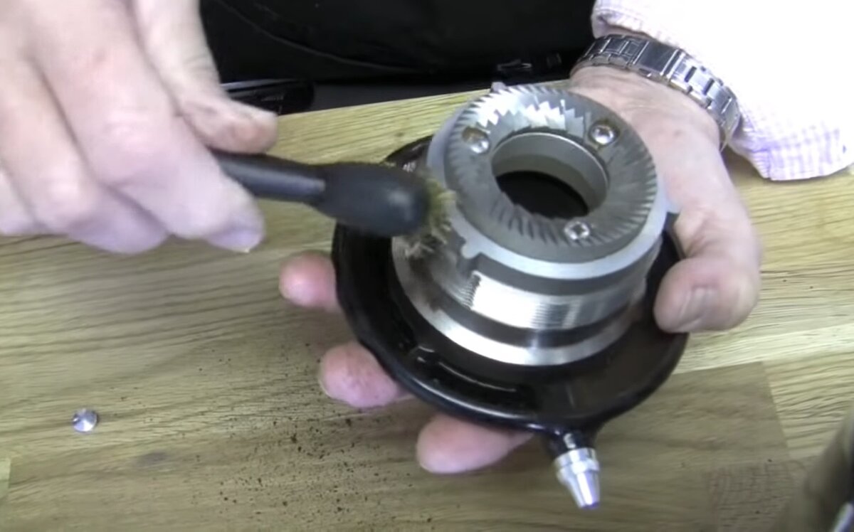 Щетка с грубой щетиной позволяет очистить узкие места жерновов