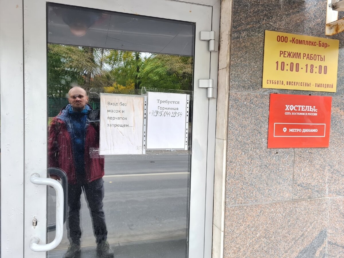 Автор отражается в заляпанной двери хостела Рус Динамо