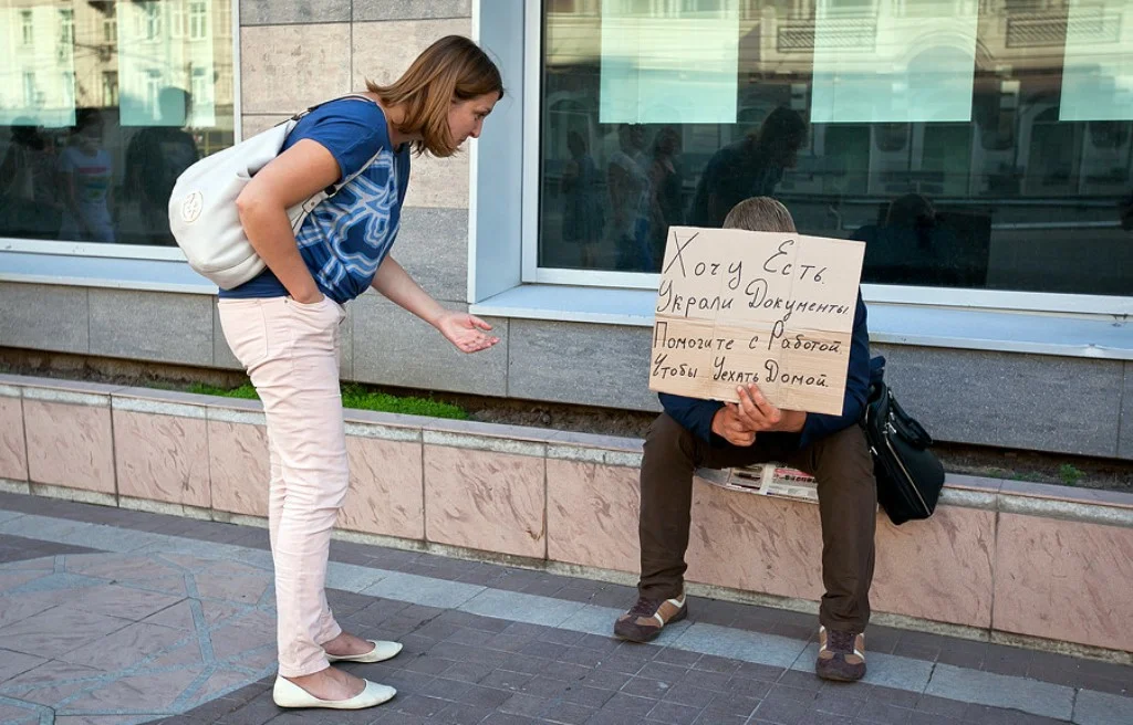 Прожить подать. Попрошайки на улицах. Просит денег. Нищий с плакатом. Попрошайка с табличкой.