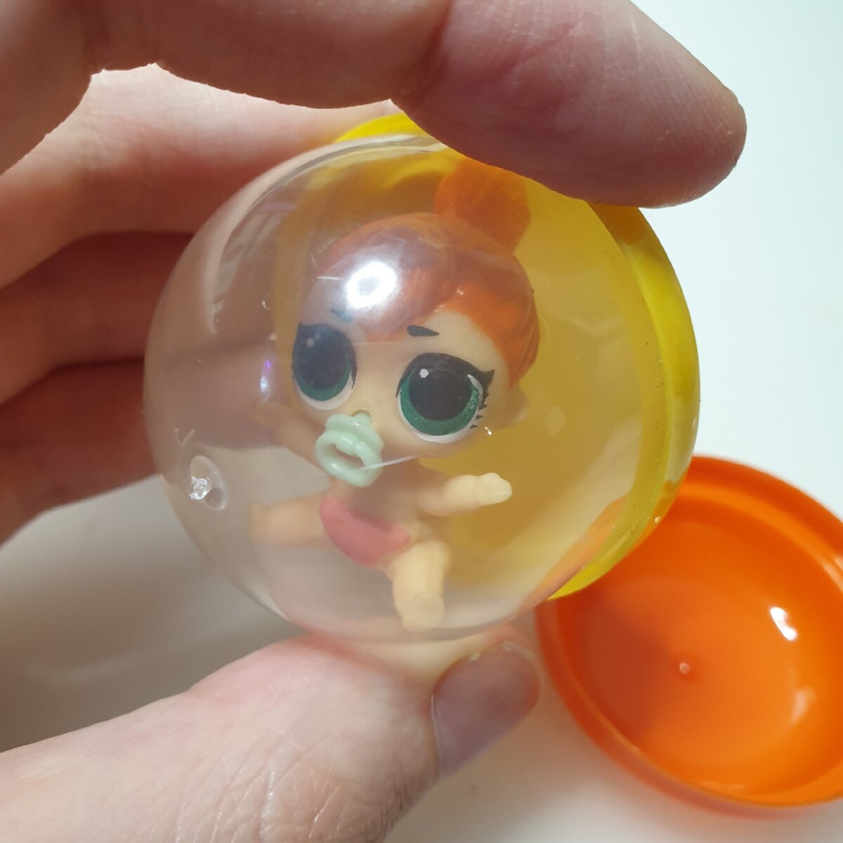 Все малышки находятся в пластиковом шарике, который достаточно легко открывается одной рукой