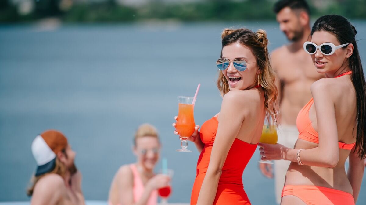 Девушки с коктейлями на пляже © Depositphotos.com / ArturVerkhovetskiy