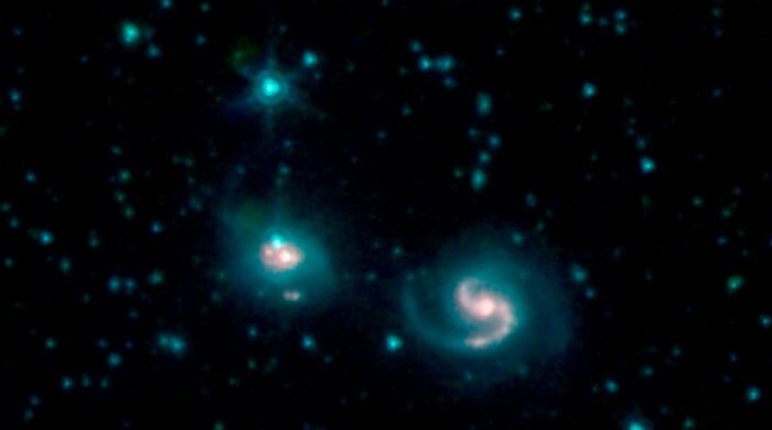На снимке: слияние двух галактик, известных как NGC 6786 (справа) и UGC 11415 (слева), совместно их называют VII Zw 96. Оно составлено из изображений от трёх каналов камеры IRAC: канал 1 – синий цвет, канал 2 – зелёный цвет и канал 3 красный цвет. Источник: NASA/JPL-Caltech 
