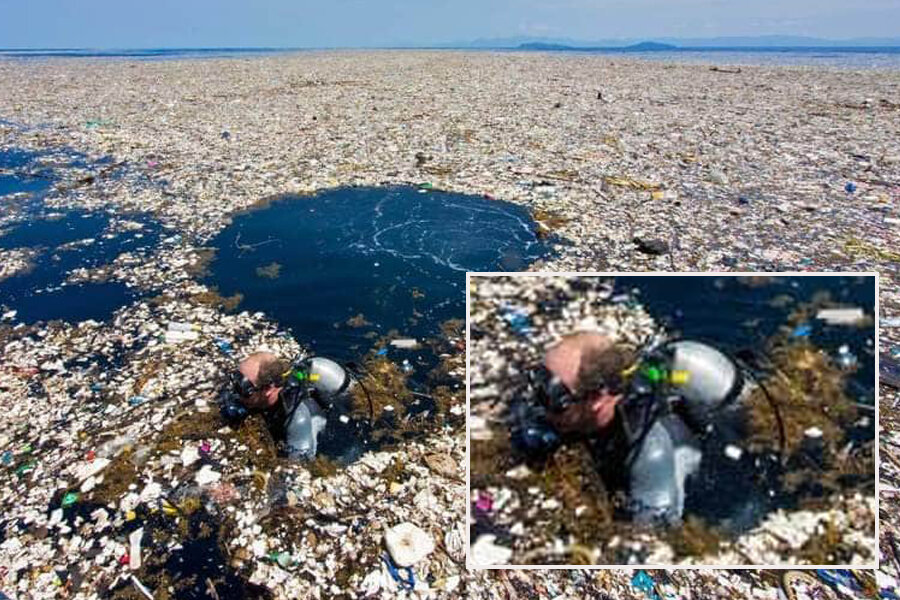 Человек с аквалангом выныривает из-под кучи плавающего в море  мусора.