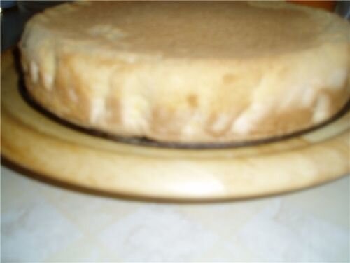     Первым делом необходимо взбить яйца с сахаром в пышную пену. Потихоньку добавляем к яйцам муку, крахмал и разрыхлитель и всё тщательно перемешиваем венчикои или ложкой, комочков в тесте быть не должно!  Берём форму для выпечки (будет прекрастно, если она разъемная), смазываем её кусочком сливочного масла и аккуратно выкладываем тесто.   Ставим заранее разогревать духовку (190 градусов), и затем помещаем в неё форму с тестом. Выпекать бисквит мы будем до готовности (проверять зубочисткой) примерно минут 20.  Готовому бисквиту лучше дать отлежаться несколько часов.  Готовый корж необходимо разрезать поперёк на две части, причём верхний должен быть тоньше. Из второго, нижнего, вынимаем мякиш и крошим его в отдельную миску.   