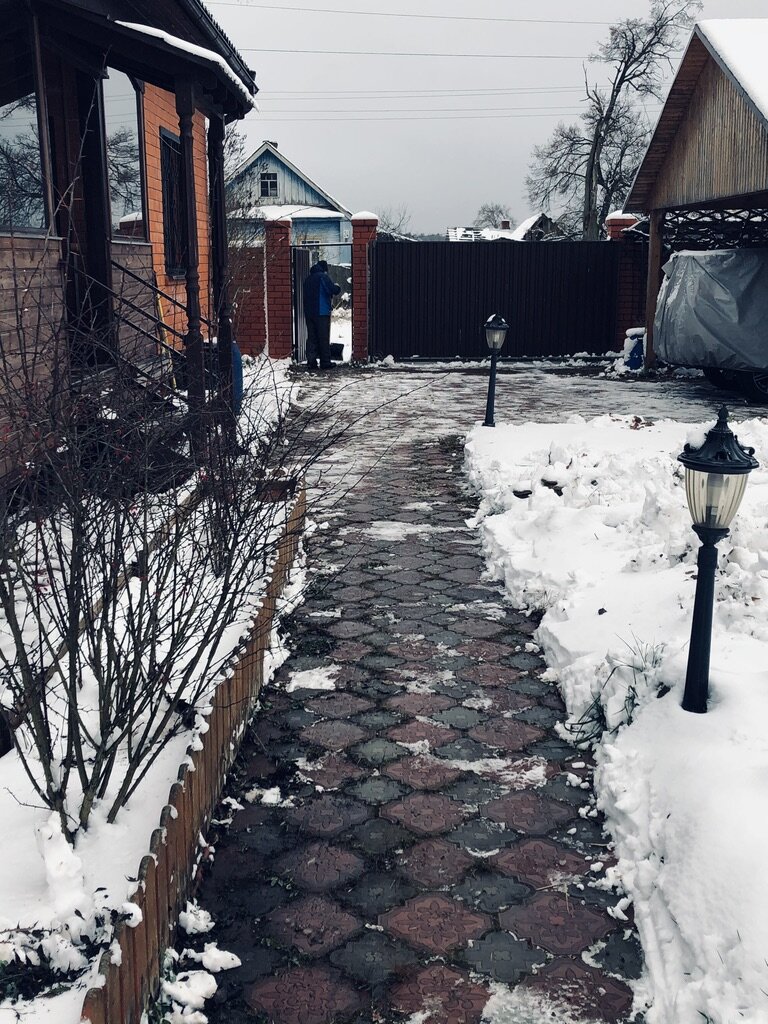 Муж чистит с двух сторон въездных ворот. 