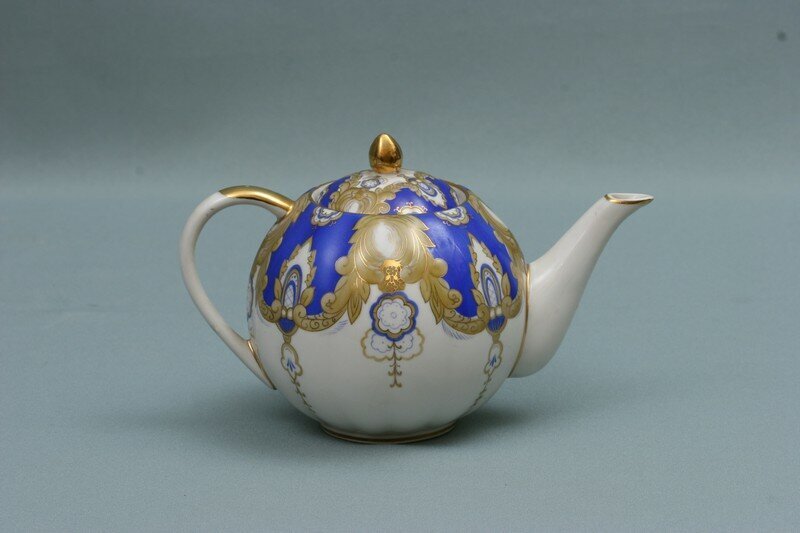 Виктор Колосов (роспись). Серафима Яковлева (форма «Тюльпан», 1936). Чайник из сервиза «Театральный». 1961. Дулёво. Высота 13 см. Государственный центральный музей современной истории России / ГИК 34207/800-1. Госкаталог: 6196848. Источник: goskatalog.ru