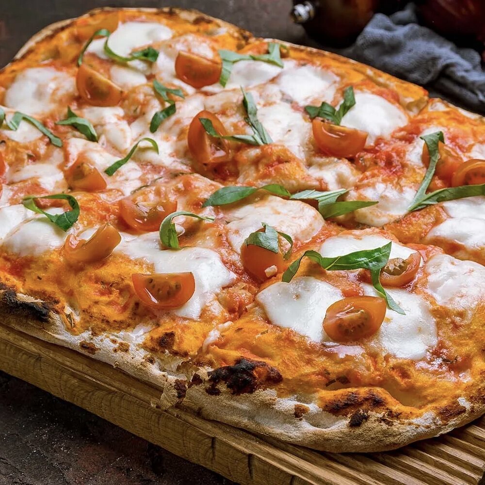 Один из самых популярных видов пиццы с моццареллой, мелкими помидорчиками и базиликом. Вот это римская пицца, приготовленная в прямоугольной форме. Обратите внимание на толщину теста. 
