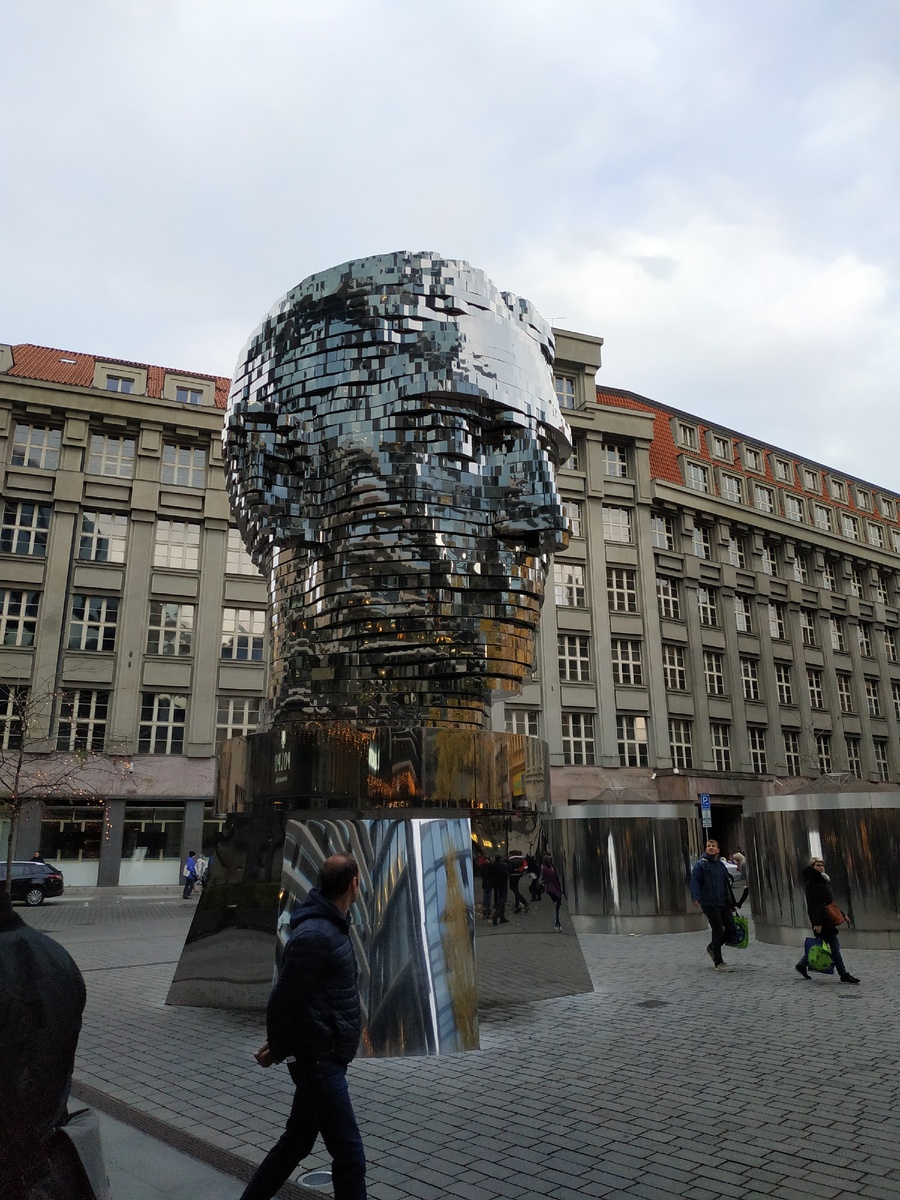 «Голова Франца Кафки»  — скульптура немецкоязычного писателя Франца Кафки авторства Давида Черного. Ну очень странный арт-объект, который состоит из множества горизонтальных слоев, которые в свою очередь вращаются, останавливаясь на несколько секунд и складываются в огромную человеческую голову.  