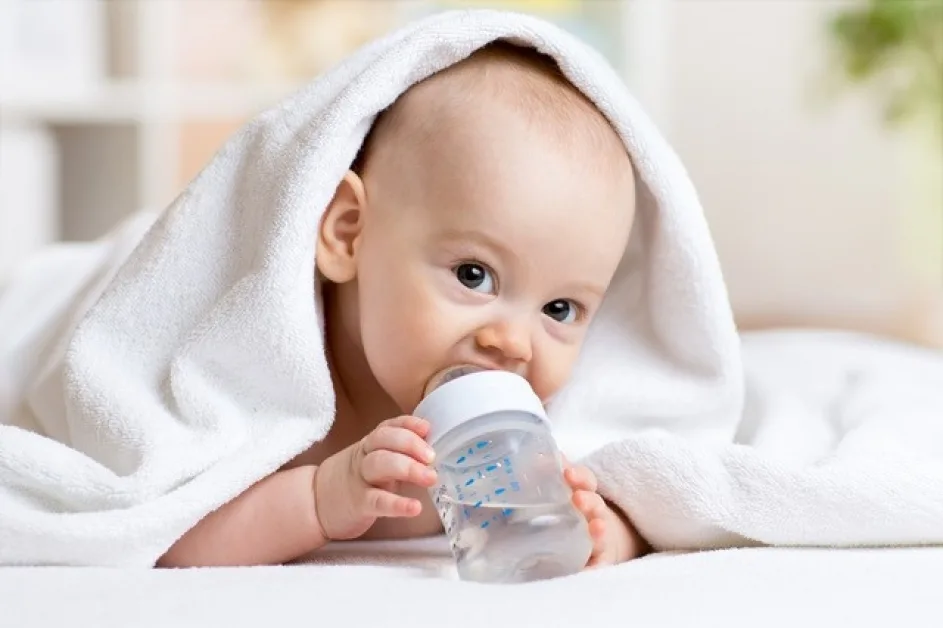 ребенок с бутылочкой. малыш с бутылочкой. питье новорожденного ребенка водой. малыш пьет. грудные дети пьют воду.