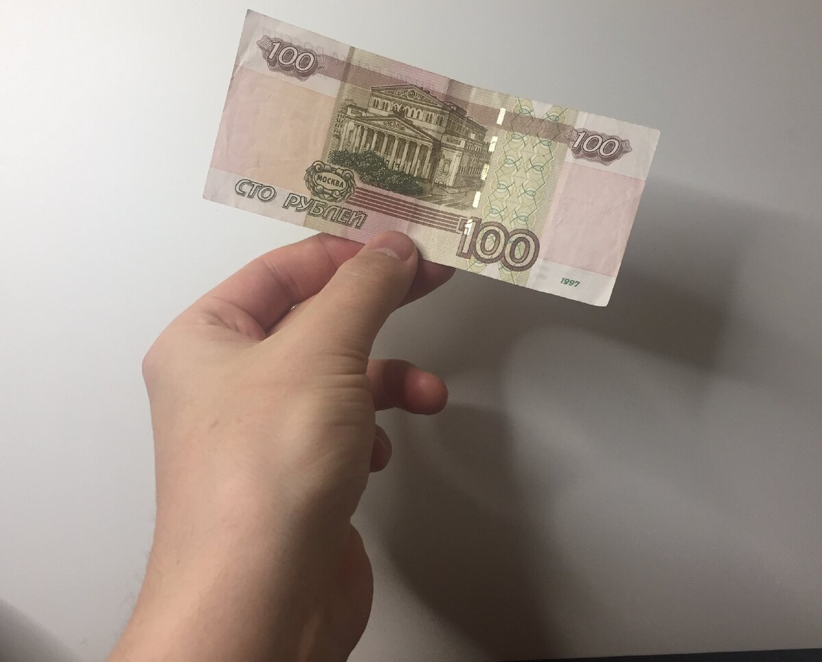 100 рублей в руке.