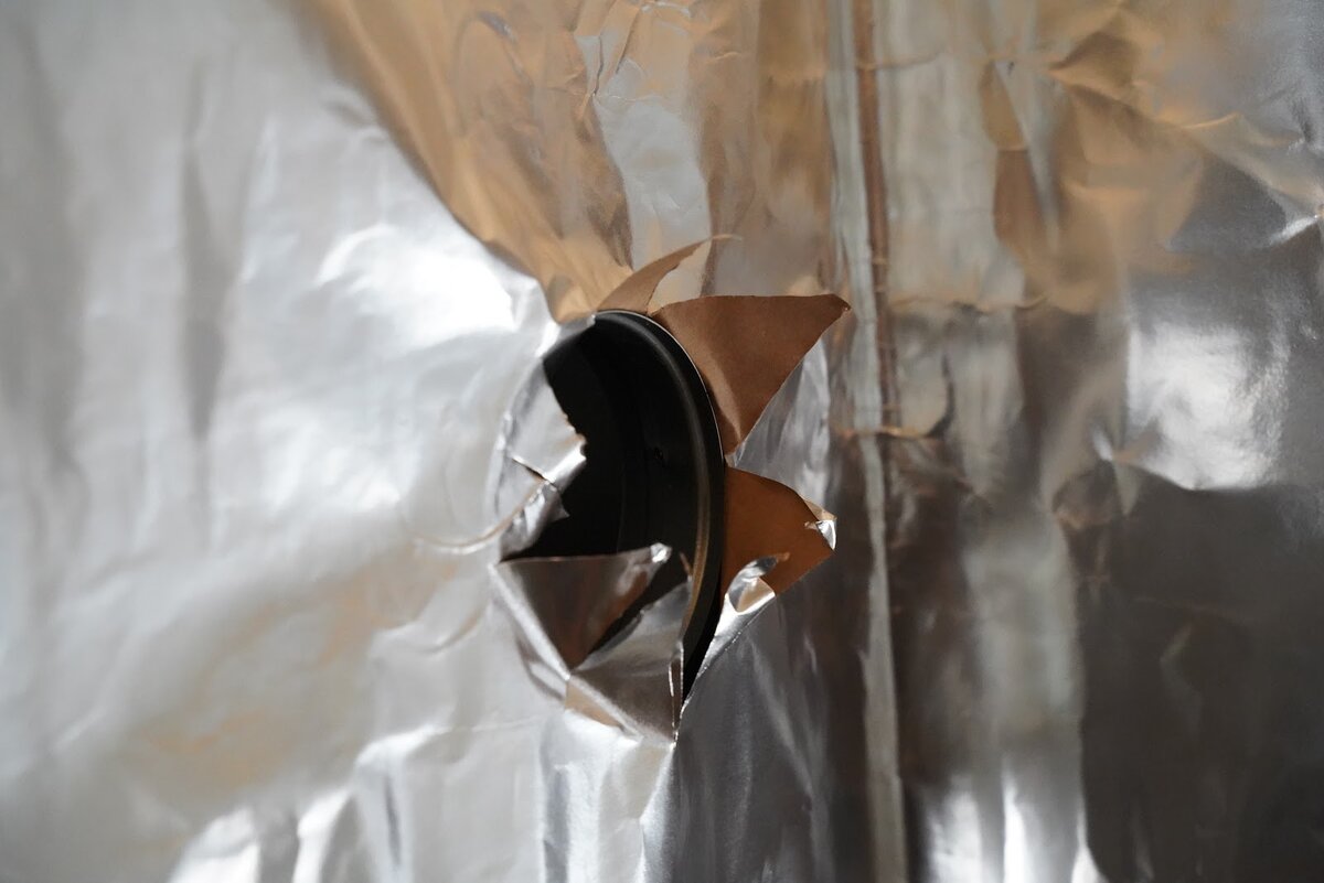 Проход вентиляционного воздуховода через изолирующую пленку. Дыру вырезаем звездочкой. Так будет удобнее изолировать. Позже оклеиваем бутиловой лентой или каким-нибудь другим липким скотчем.