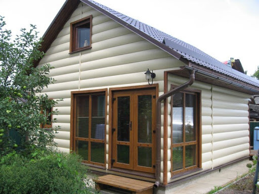 Обшивка небольшого загородного дома виниловым блок-хаусом.