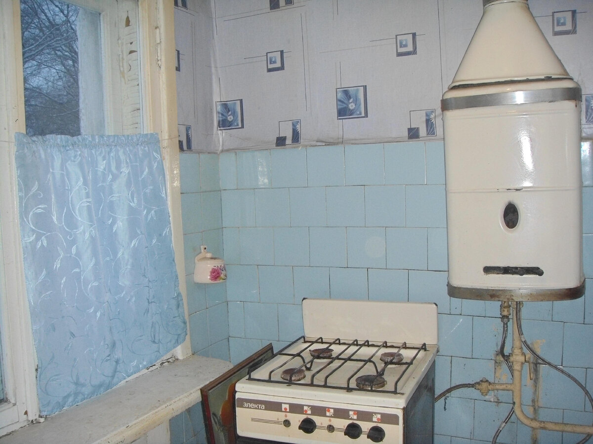Старая кухня с советской регулируемой газовой колонкой.