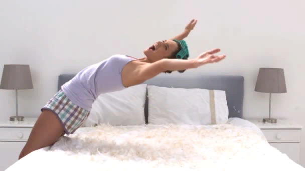 Человек над кроватью. Девушка в чёрном на кровати. Девушка падает на кровать. Весело прыгают на кровати. Девушка в платье падает назад на кровать.