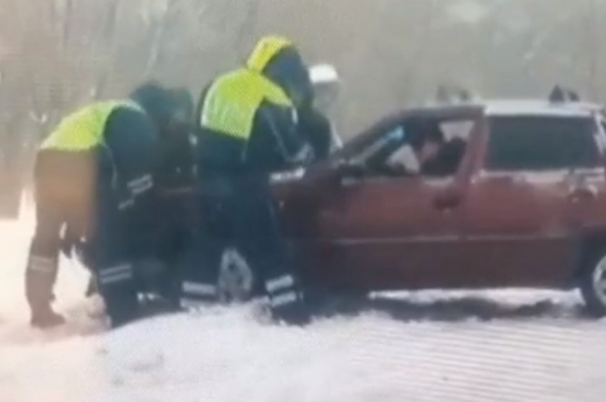    В Орске сотрудники ГАИ вытаскивают попавших в плен стихии водителей.