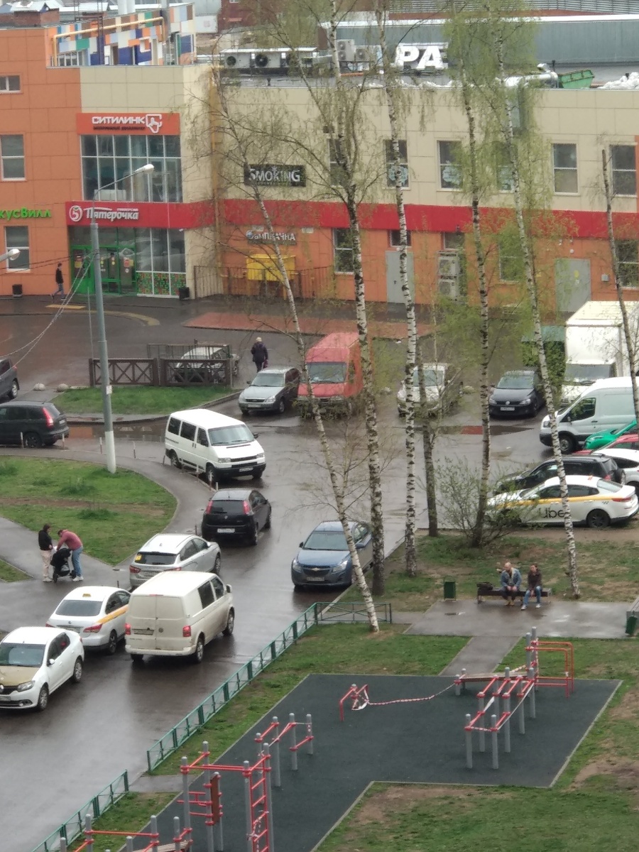 Люди гуляют с колясками, болтают, сидя на лавочке
