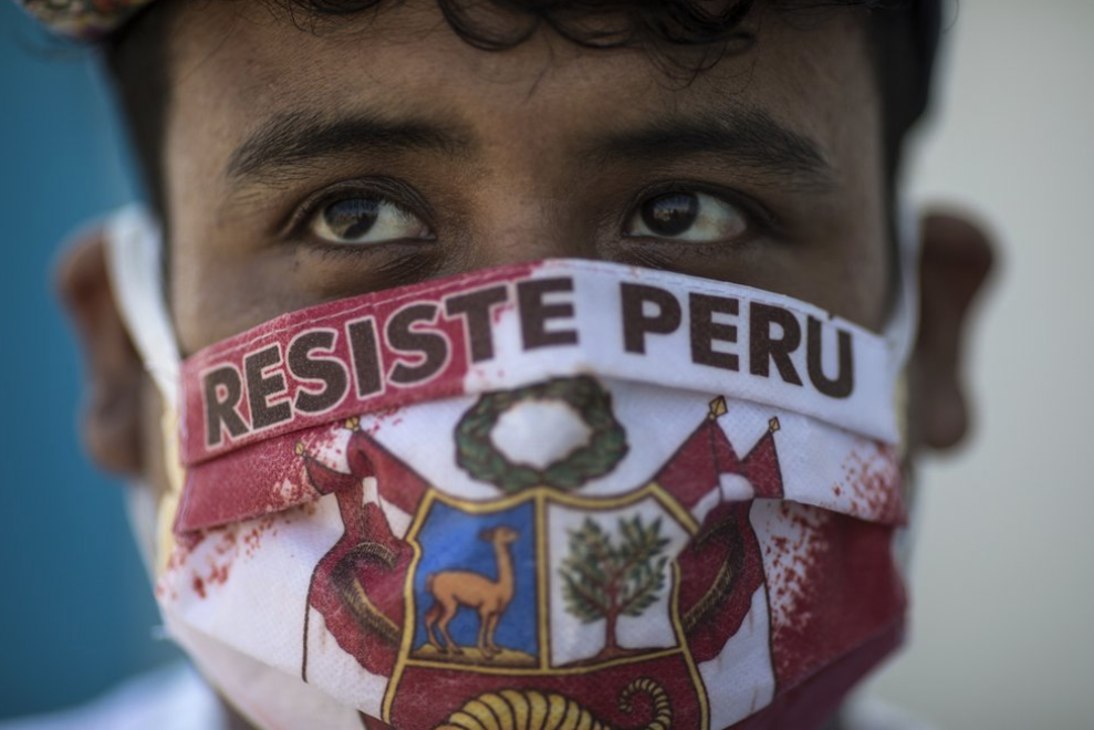 Джон Санчес носит лицевую маску с надписью «Resist Peru» на испанском языке.