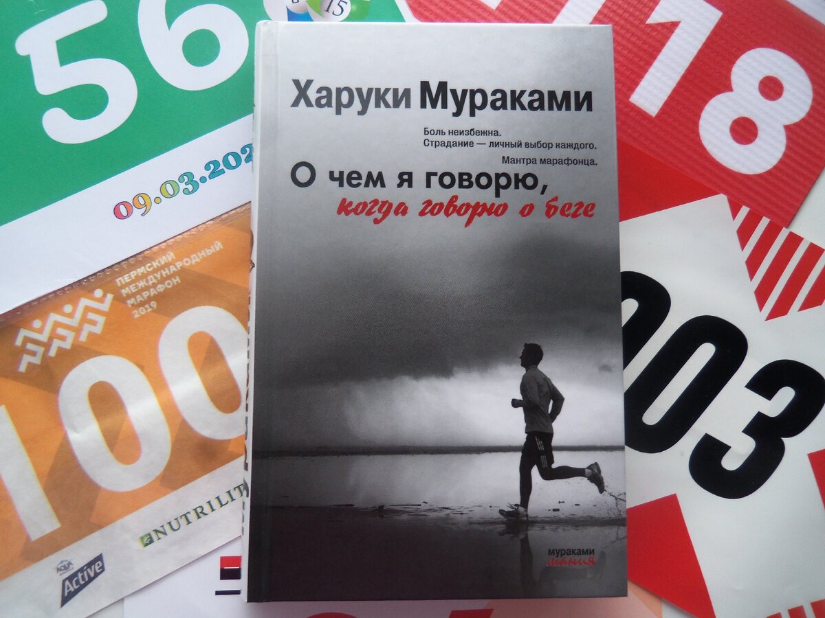 Книга на фоне моей коллекции беговых номеров