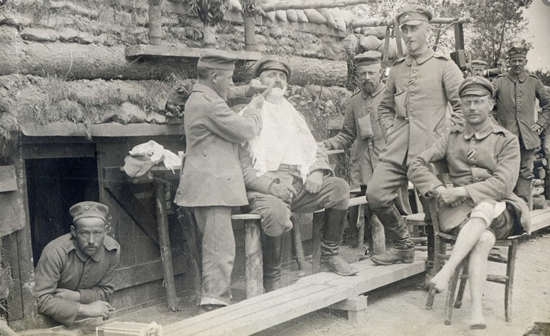 Немецкий окоп. Офицеру бритвой сбривают щетину. 