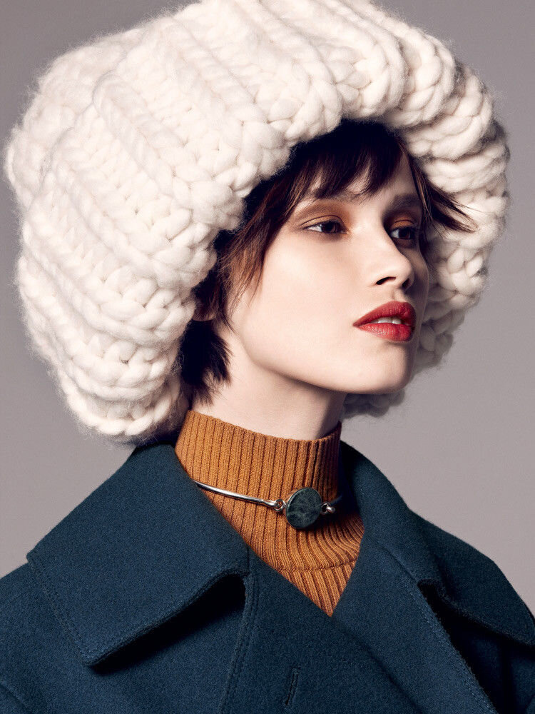 Объемная вязаная шапка крупной вязки белого цвета выглядит очень эффектно