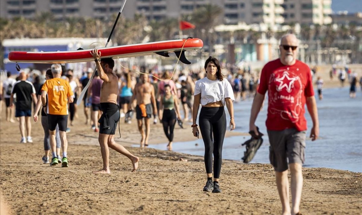 Граждане прогуливаются вдоль пляжа Мальварроса в Валенсии, в первый день  разрешения занятий спортом и прогулок на свежем воздухе. Фото MIGUEL LORENZO