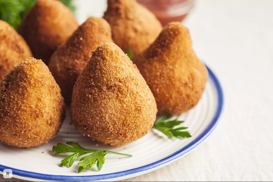 Необходимые индигриенты: 

Положите куриные грудки в большую неглубокую кастрюлю. Покройте их куриным бульоном, добавив воду, если это необходимо, чтобы покрыть по крайней мере 1/2 дюйма жидкости.


Добавьте морковь и одну луковицу (очищенную и разрезанную пополам), а также лавровый лист.


Доведите жидкость до слабого кипения и готовьте в течение 15-20 минут или до тех пор, пока курица не будет просто приготовлена (едва розовая в середине самой толстой части). Если некоторые из грудей варятся быстрее, вы можете удалить их раньше.


Отложите курицу в сторону, чтобы она остыла, процедите и оставьте бульон.


Измельчите курицу на очень мелкие кусочки с помощью кухонного комбайна, оснащенного пластиковым лезвием или вилками.

Смешайте размягченный сливочный сыр и сок лайма с измельченной курицей.

Мелко нарежьте вторую луковицу и чеснок. Обжарьте лук и чеснок в 2 столовых ложках сливочного масла до золотистого цвета и мягкости.

Добавьте горячий лук и чеснок в куриную смесь и перемешайте, пока все не будет хорошо перемешано.

Отмерьте куриный бульон (вероятно, у вас будет около 3 1/2 стакана). Если у вас меньше трех чашек, добавьте больше куриного бульона, чтобы сделать 3 чашки. Доведите куриный бульон до кипения в кастрюле и постепенно размешайте в том же количестве муки, что и бульон (поэтому, если у вас есть 3 1/2 стакана бульона, добавьте 3 1/2 стакана муки).

Энергично перемешайте и готовьте 2-3 минуты. Смесь превратится в жесткое тесто. Снять с огня и охладить в холодильнике в течение 1 часа.

В этот момент Вы можете охладить куриную смесь и тесто в течение нескольких часов.

обмакнуть руки в муку, сформировать коксины, скатав их в размер мячей для гольфа, а затем выдолбите середину для начинки.

Нажмите на кусочек куриной начинки размером с мяч для гольфа (около 1 1/2 столовой ложки) внутри шарика теста и плотно прижмите тесто вокруг начинки.

Подтяните боковые стороны теста, чтобы приблизить форму голени, посыпая мукой руки по мере необходимости.

Поставьте коксины на противень заостренным концом вверх. Продолжайте, пока не закончится тесто или начинка.

Взбейте яйца вместе в миске. Положите хлебные крошки в неглубокую кастрюлю и приправьте солью и перцем.

Окуните коксинью в яйцо,затем в панировочные сухари, чтобы покрыть. Остудите панированные коксины в течение часа.

Нагрейте кастрюлю с толстым дном с достаточным количеством масла, чтобы покрыть масло коксиньяса до 360 F. Обжаривайте их порциями до темно-золотистого цвета.

Подавайте теплым и наслаждайтесь!

Советы
Это блюдо лучше всего, если вы начнете их за день до того, как зажарите.
Если вам посчастливилось найти catupiry, бразильский сливочный сыр, используйте его вместо сливочного сыра.