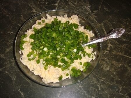     Сыр лучше всего брать тот, который легко плавится. Я предпочитаю российский.  В миску крупно натираем на терке сыр.  Зелёный лук промываем и мелко нарезаем на доске. Добавляем его к сыру, перемешиваем и вбиваем 2 яйца и размягчённое сливочное масло. Тщательно всё перемешиваем ложкой.   