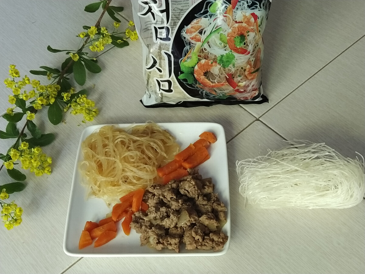 На блюде фунчоза тушеная в соевом соусе с морковью и мясом.